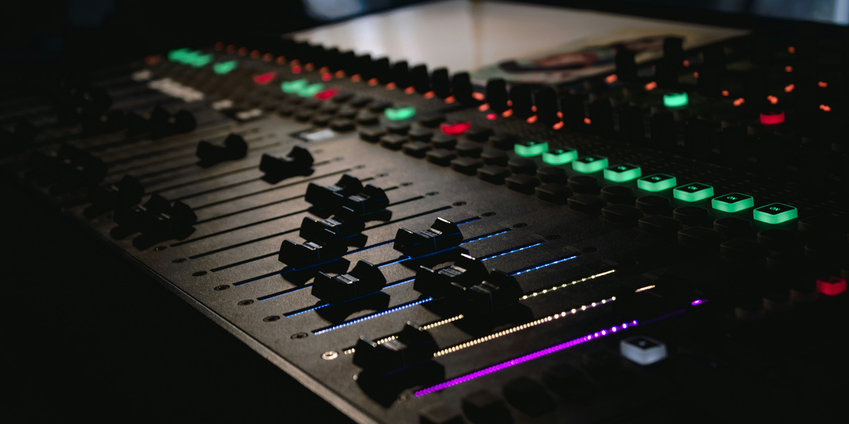 Illuminated faders and controls on a studio audio mixing console